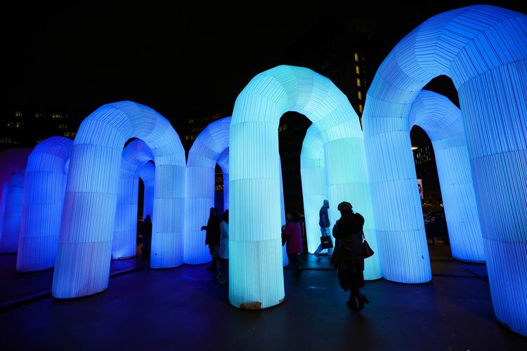 11月30日,游客在比利时布鲁塞尔的舒曼广场欣赏灯光艺术装置"天空