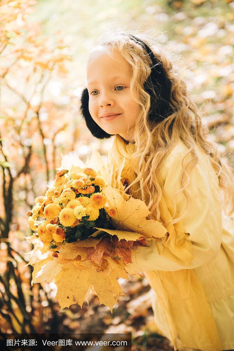 金色头发的美丽小女孩在秋天的背景下
