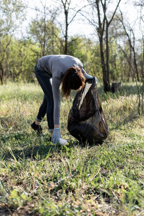 年轻的女志愿者在公园里收集垃圾保护环境免受垃圾污染的概念