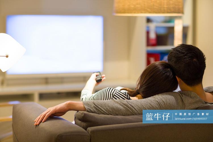 年轻情侣在客厅沙发上看电视