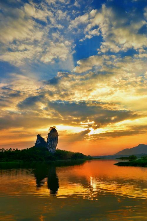 夕阳西下时的江边鱼王石