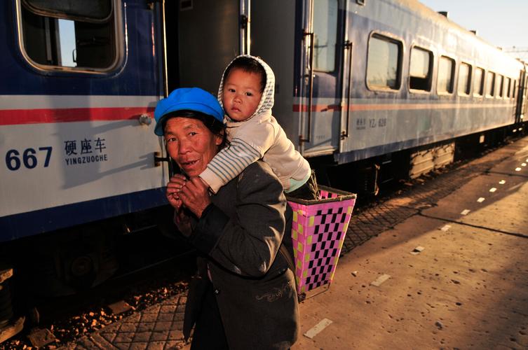 的客运列车基本上是铁路职工的通勤车图为一个准备上车的背孩子的老人