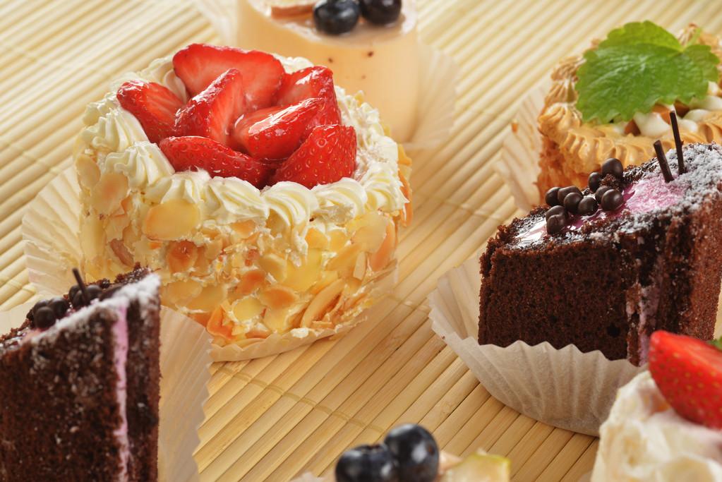 小蛋糕,小奶油蛋糕和竹表布的莓果