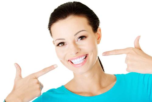 白色背景下微笑露出洁白的牙齿的女人