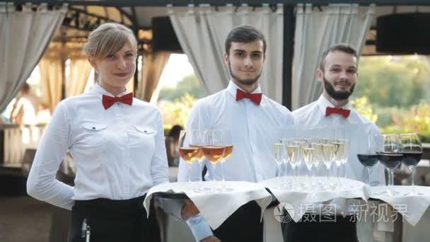 服务员招呼客人与含酒精饮料.香槟, 红, 白葡萄酒在托盘上短视频