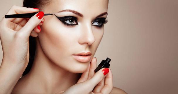 美丽的女人化妆眼与黑色班轮.时尚化妆 i>箭 /i>.红指甲完美肌肤
