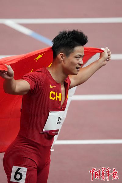 中国选手苏炳添身披国旗,他成为首位闯进奥运男子百米决赛的中国人