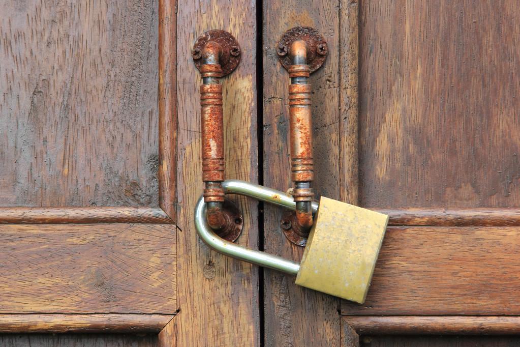 生锈的锁,生锈的老锁在木制的门上