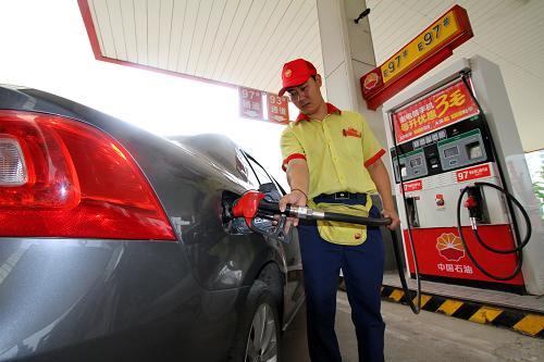7月7日,河北省邯郸县一加油站工作人员在给汽车加油.