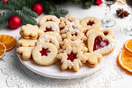 传统的林泽圣诞饼干,装满草莓酱,摆在盘子里照片