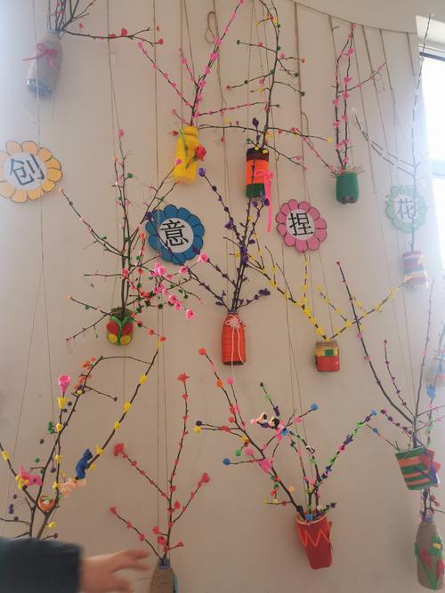 利用树枝和彩泥,大一班的孩子们制作的形象生动树枝花