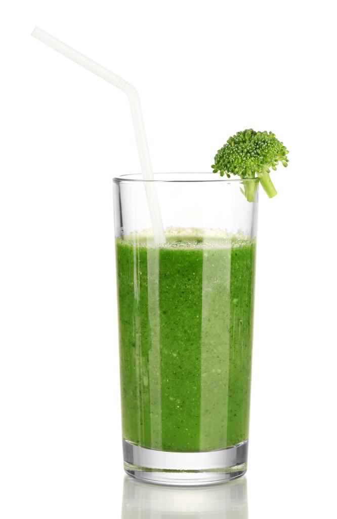 绿色蔬菜汁在玻璃上白色隔离