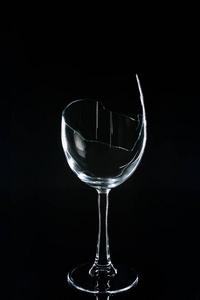 透明反光黑色反光表上的碎酒杯照片