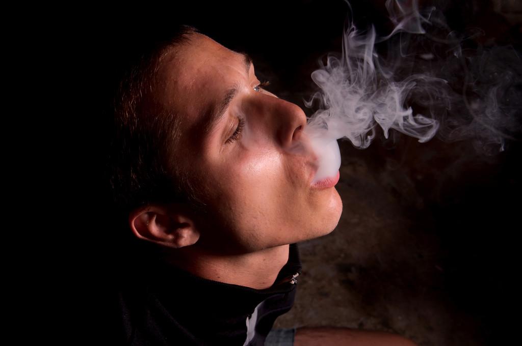 吸烟,年轻人吸烟与黑色背景