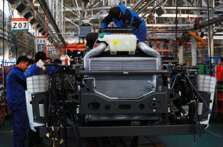 11月22日,工人们在中国重汽集团济宁商用车总装生产线上装配汽车.