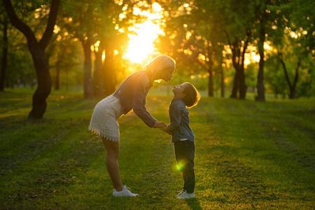 母亲和小儿子在公园或森林,在户外.拥抱,让大家一起开心照片