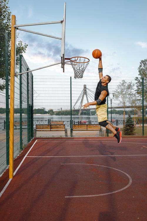 篮球运动员在跳投时投篮. 男子运动员在街头篮球训练中的运动服成绩