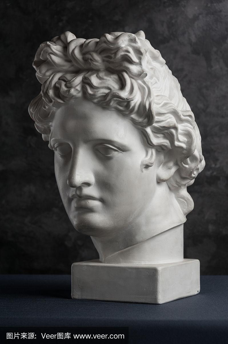 在黑色纹理背景上的古代阿波罗雕像的石膏复制品.石膏雕塑人的脸.