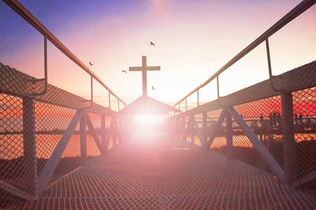 天堂之路 conceptsilhouette 基督徒十字架在桥梁和橙色天空与照明
