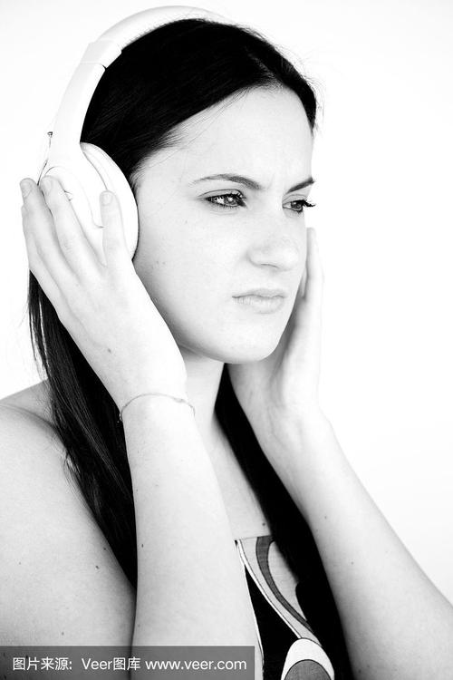 悲伤的女人戴着耳机听着黑白音乐