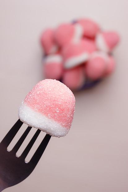 甜食粉红色的口香糖糖果糖特写手叉子伸出手碗里糖果的风景