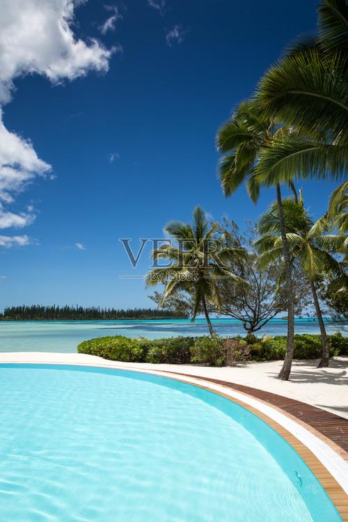 在完美的阳光明媚的一天热带度假村的无限游泳池照片摄影图片