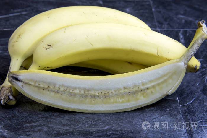 香蕉切成两半在黑色的大理石上