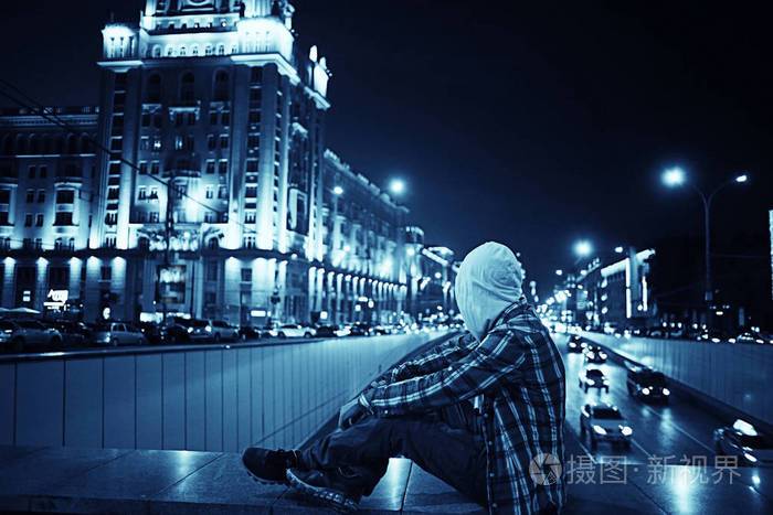 男人和夜晚城市灯光城市孤独的人概念强调道路汽车城市灯光的背景