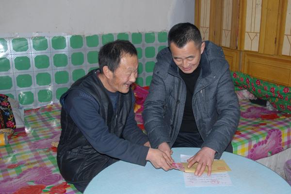 合作社经理刘生将分红送到行动不便的贫困户家中