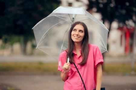 在雨中拿着透明雨伞的女人照片