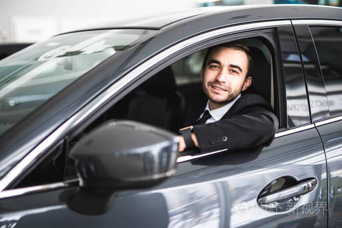 快乐的微笑新司机在车上,年轻的成功商人的肖像