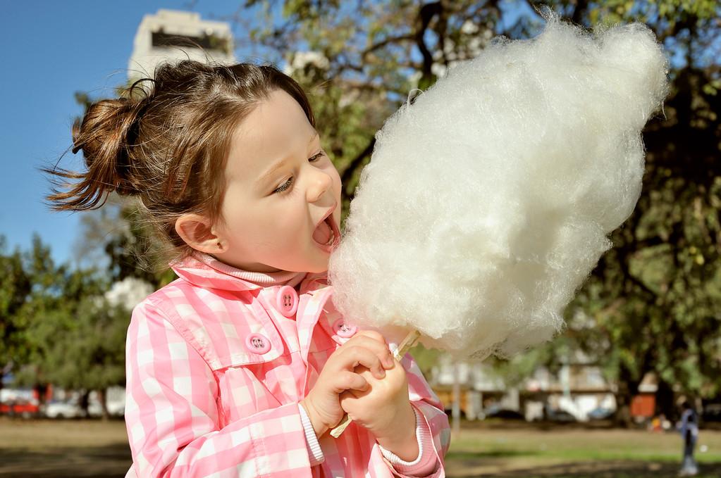 漂亮的小女孩,漂亮的小女孩在公园里吃棉花糖