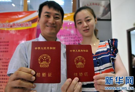 在郑州市金水区民政局婚姻登记处,两位新人展示刚刚领取的结婚证