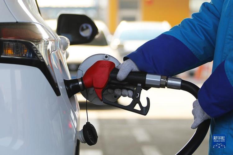 12月19日,山东省滕州市一加油站工作人员在给汽车加油.