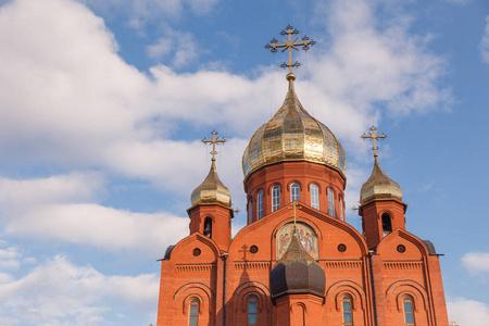 对天空的教会在克麦罗沃的老红砖基督教会与黄金和镀金的圆顶对蓝天.