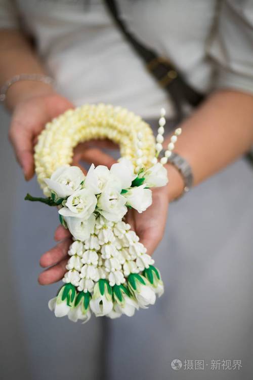 手拿着美丽的泰国茉莉花花环捧白色泰国花环