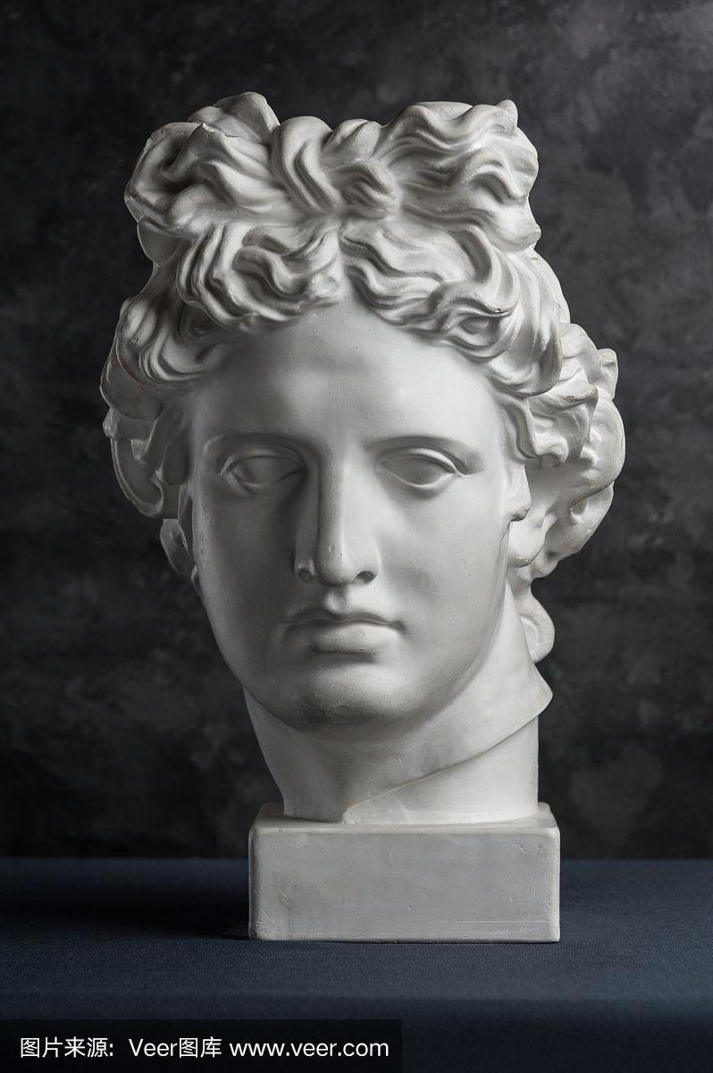 在黑色纹理背景上的古代阿波罗雕像的石膏复制品.石膏雕塑人的脸.