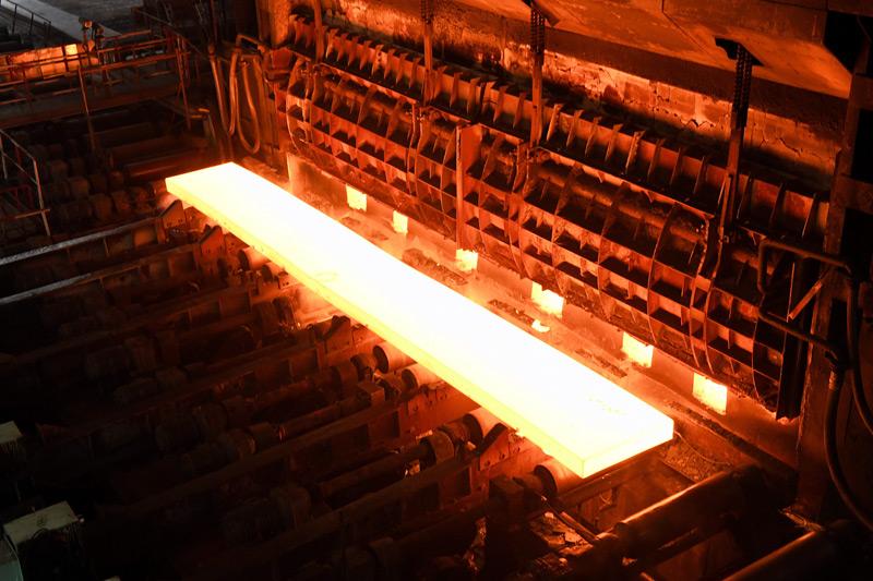 8月24日,在柳钢集团热轧厂生产车间,生产线加热炉正在出钢.石峰摄