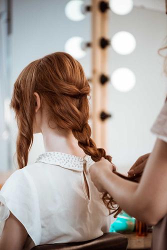 女理发师做发型在美容院的红发女孩