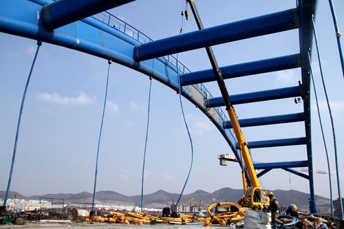 3月6日,青荣城际铁路建筑工人正在用吊车为温泉段拱桥两边安装吊杆.