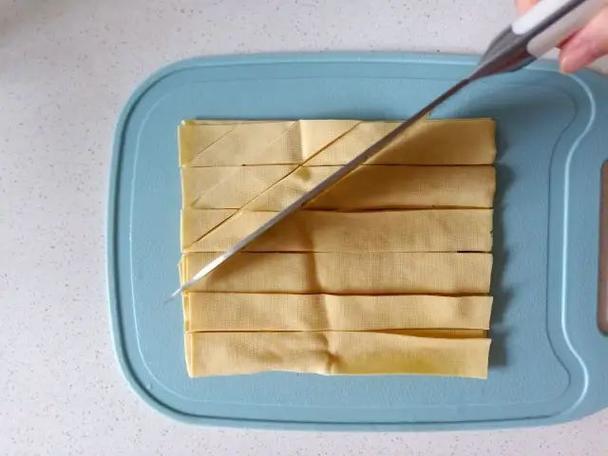 2,把豆腐皮均匀切成一条一条的,像是我下面这样的切就好了,然后再用刀