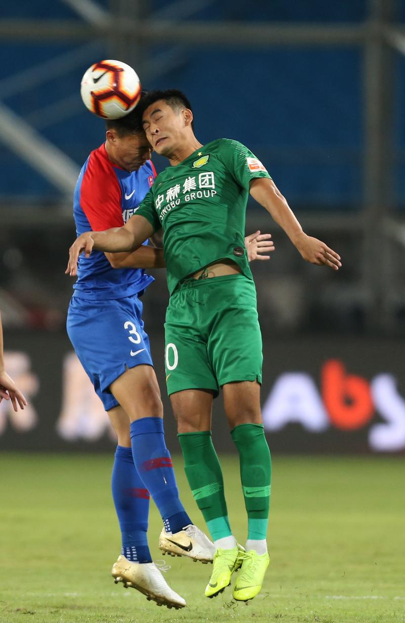 7月10日,北京中赫国安队球员王子铭(右)与重庆斯威队球员杨帅在比赛