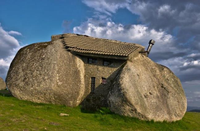 从外面来看,这个房子看起来像一个真正的大石头,屋顶放在顶部,一些