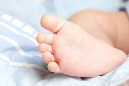 宝宝小脚丫新生婴儿在蓝色的小脚丫照片
