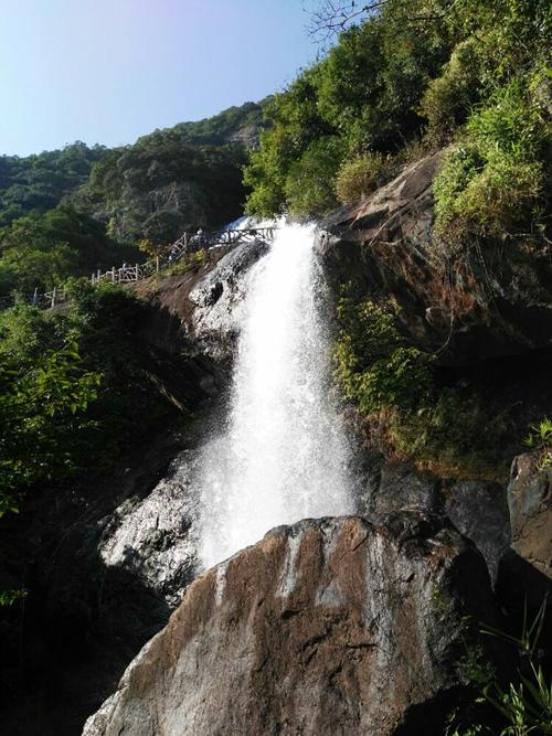 5米的神奇瀑布从白水寨山顶飞流直下,洁白纯净;另一边是9999级石阶的