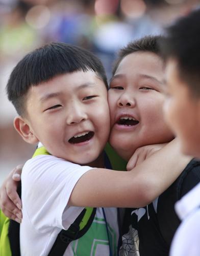 9月1日,河南省汤阴县第一实验小学三年级学生田佳民(左)和张辰瑜拥抱