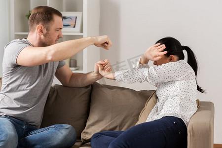 家庭暴力,虐待和人的概念——夫妻吵架,男人在家里殴打无助的女人.