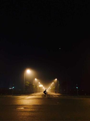 十月份晚上八点,骑着自行车回家的女生.