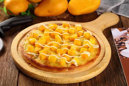 木制平底锅中的夏日芒果披萨图片