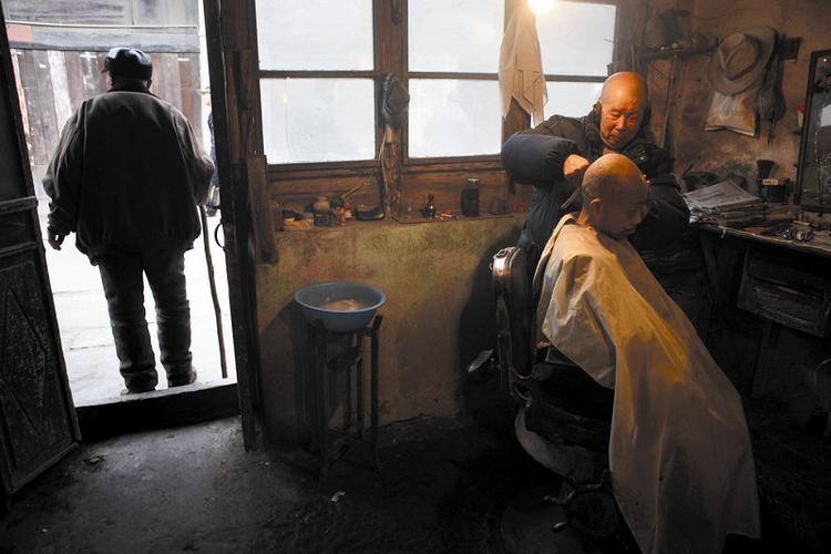 2010年2月8日,王德恒师傅在给老顾客剃光头.